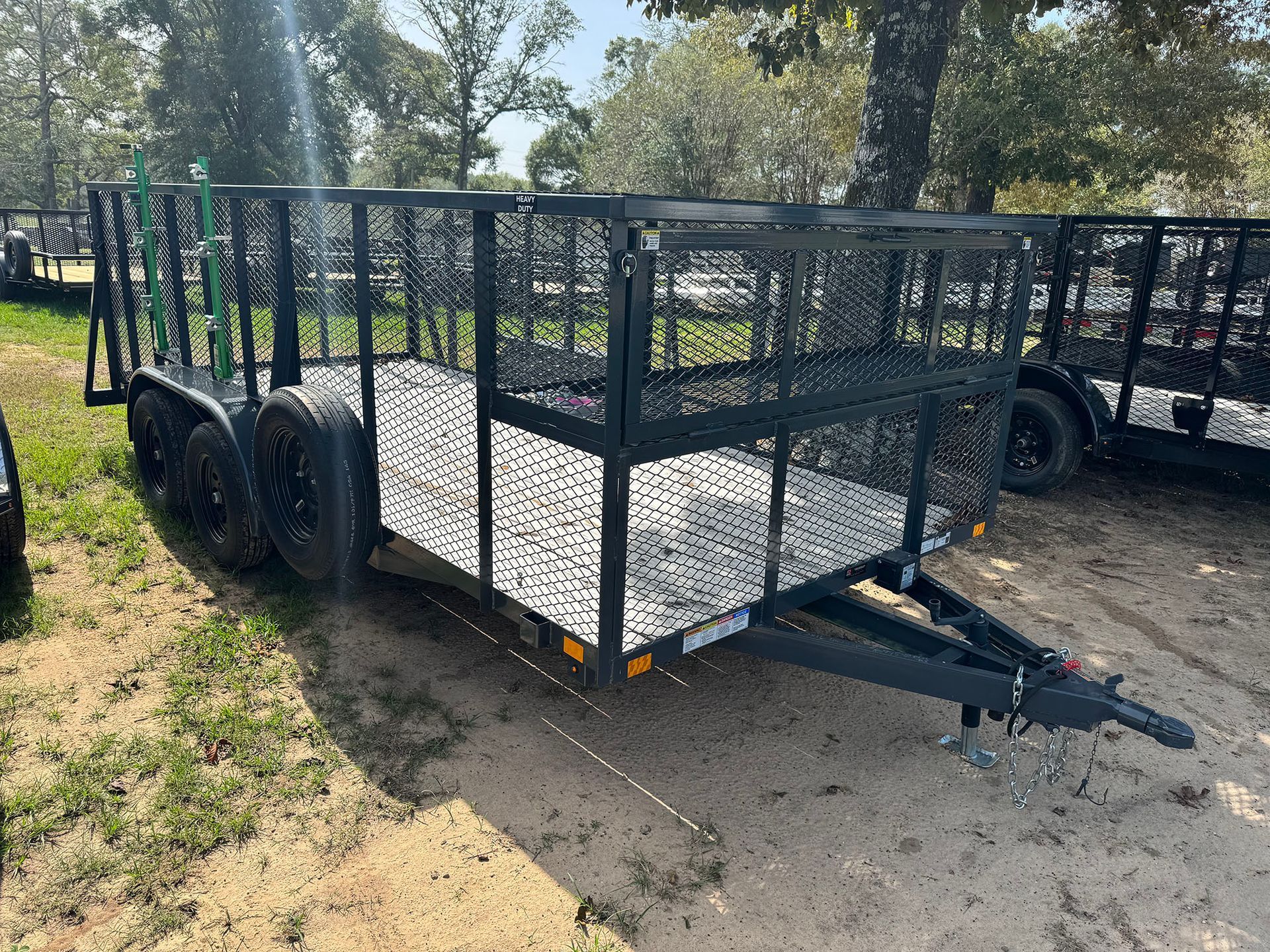A trailer is parked in the dirt in a field.