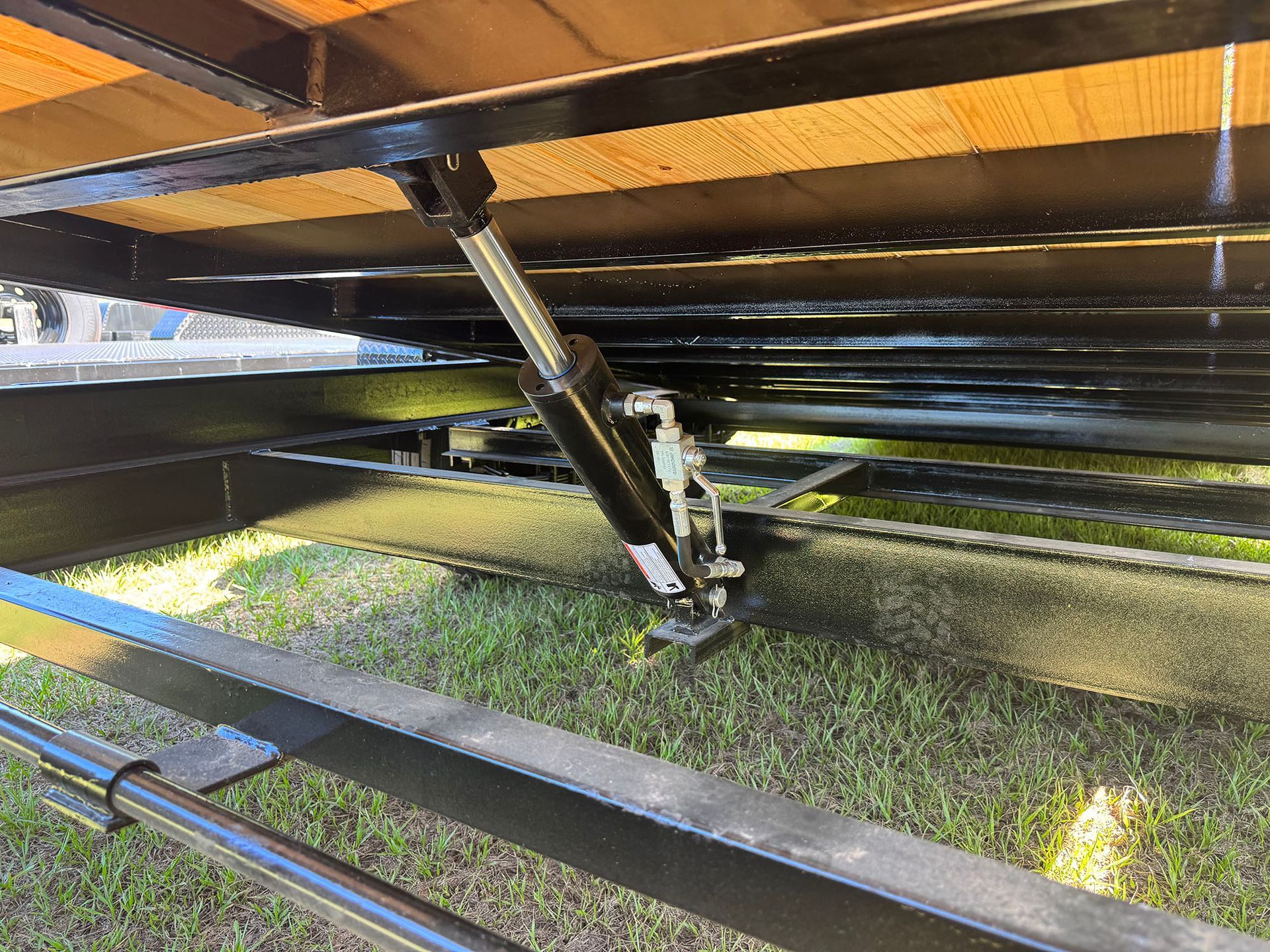 A trailer is sitting on top of a lush green field.