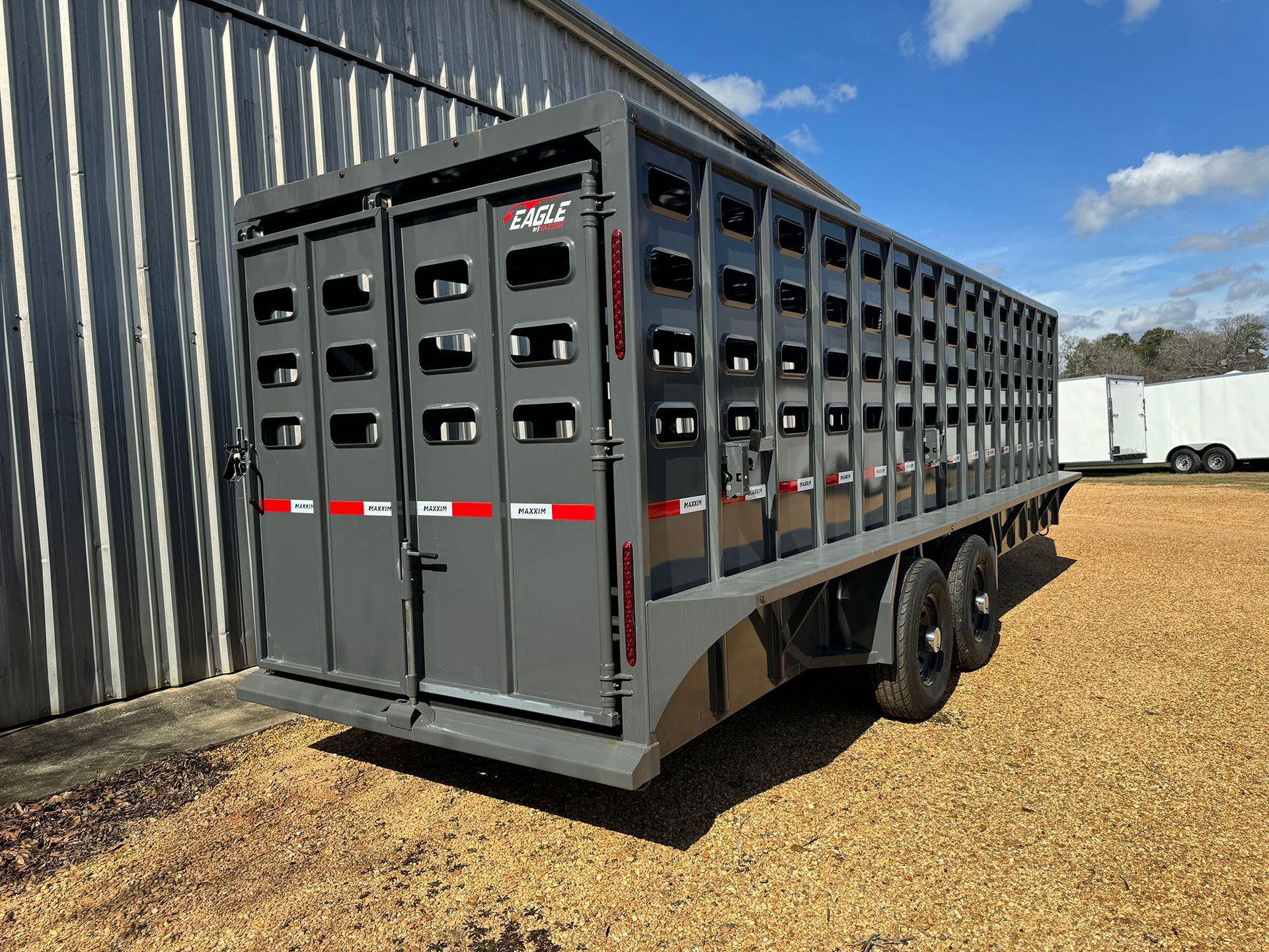 A horse trailer is parked in front of a building.