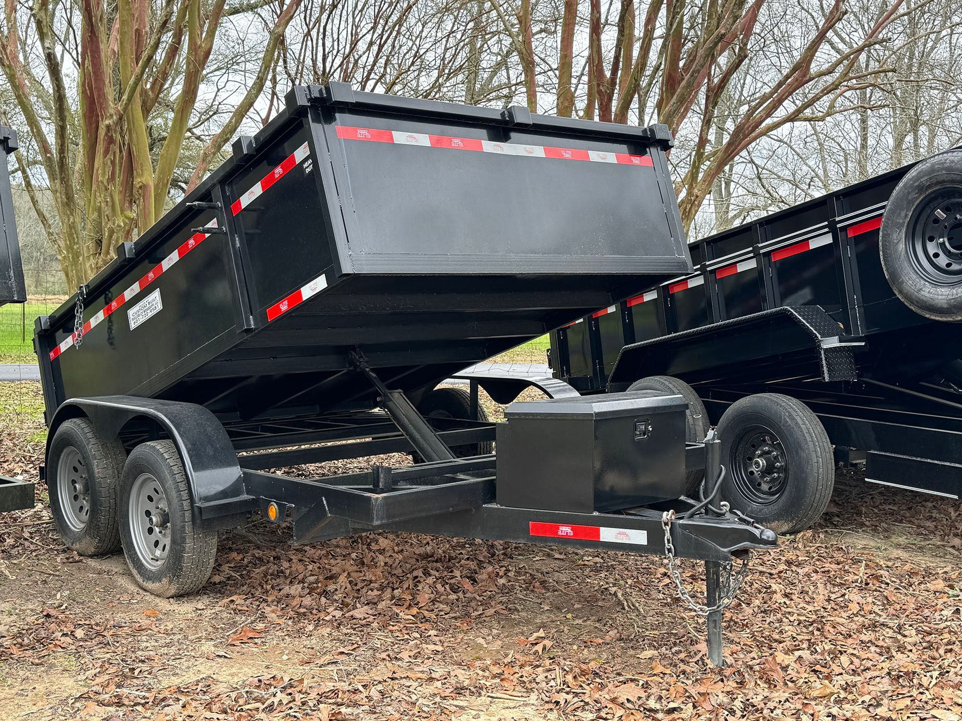 A dump trailer is sitting on top of a pile of leaves.