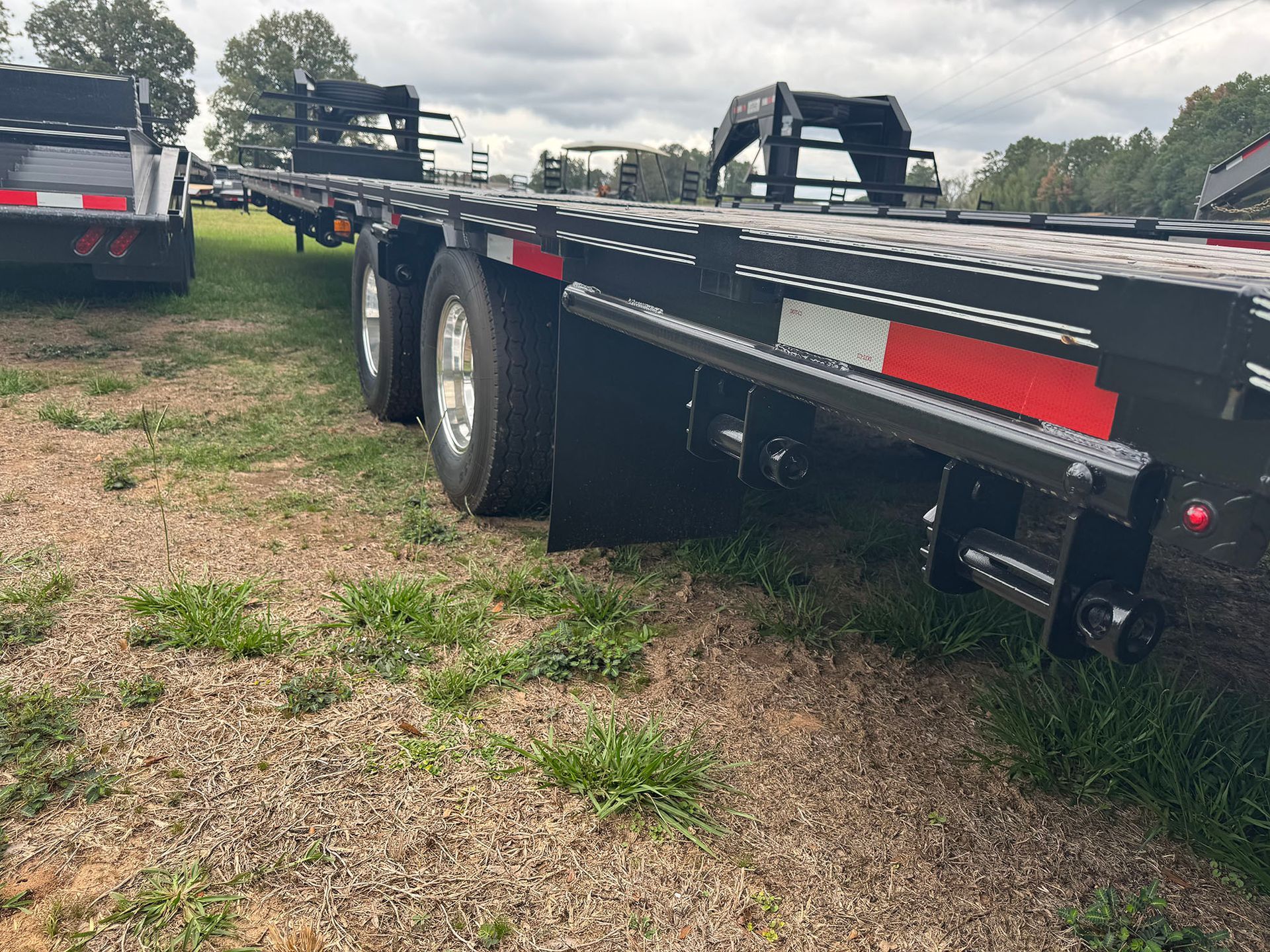 A flatbed trailer is parked in a grassy field.