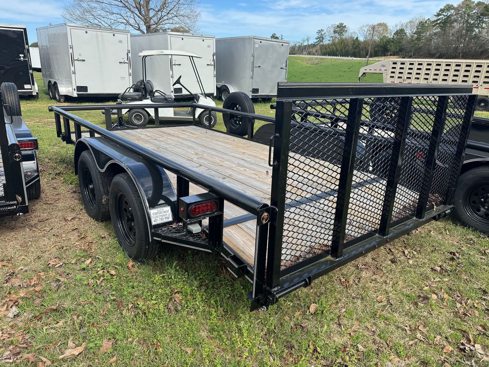 A trailer is parked in a grassy field.