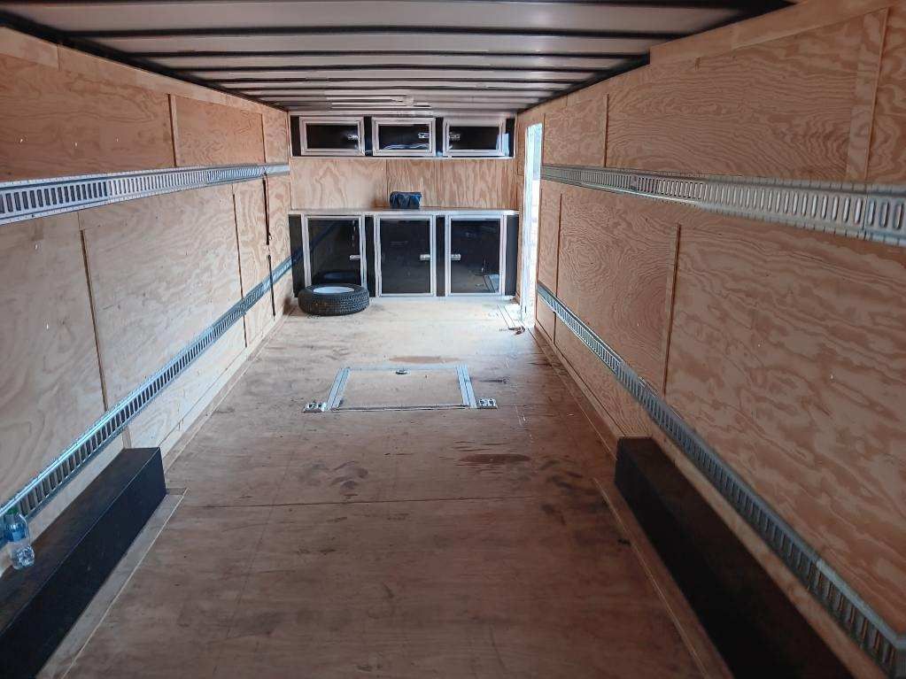 The inside of an empty trailer with wooden walls