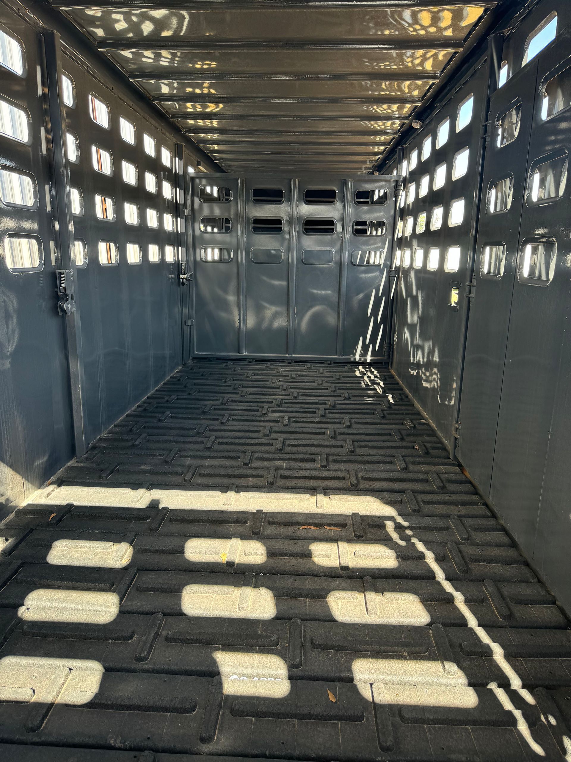 The inside of a horse trailer with a brick floor.