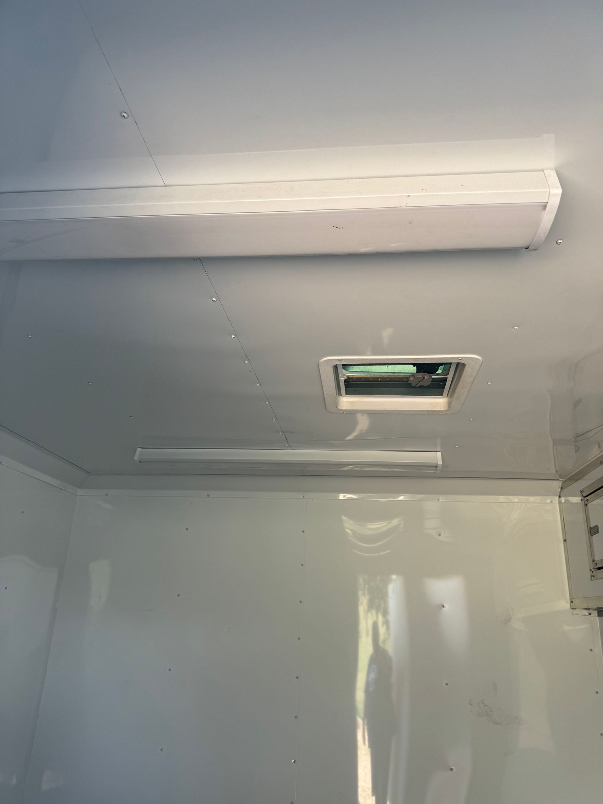 A room with a ceiling fan and a light on it.