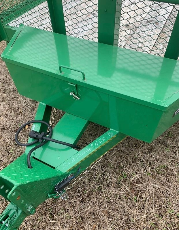 A green trailer with a toolbox attached to it.