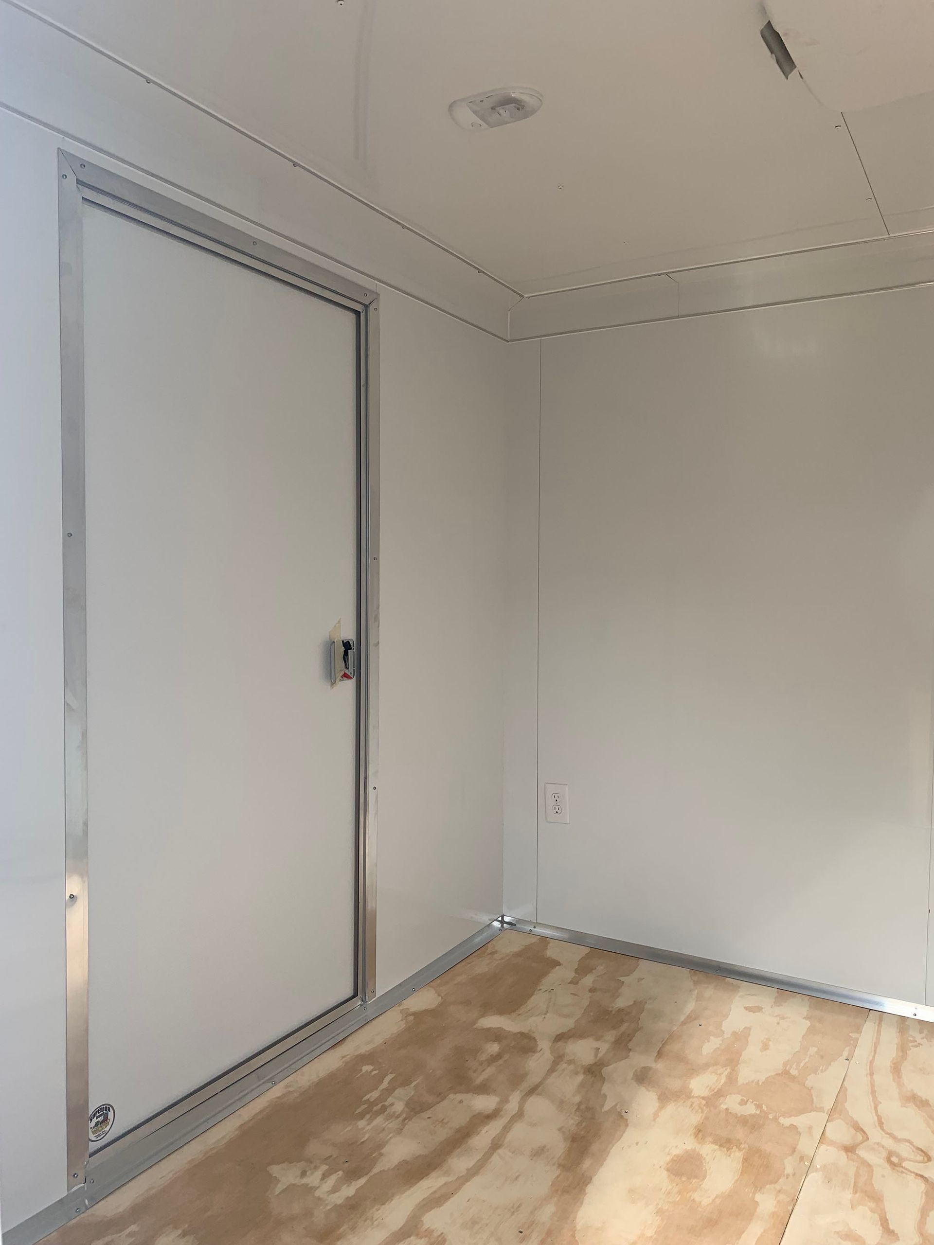 An empty room with a door and a wooden floor.