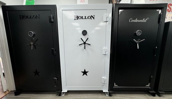 Three large gun safes; black, white, and black; labeled 