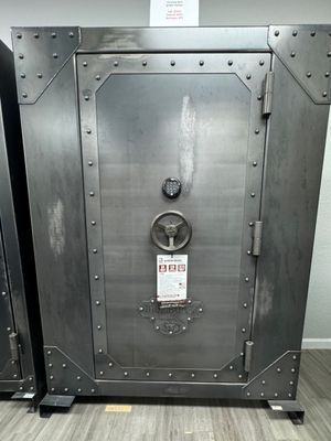 Large, industrial-style safe with a metal door, rivets, and a combination dial.
