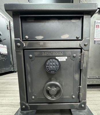 Dark gray steel safe with a digital keypad and handle, bearing the word 