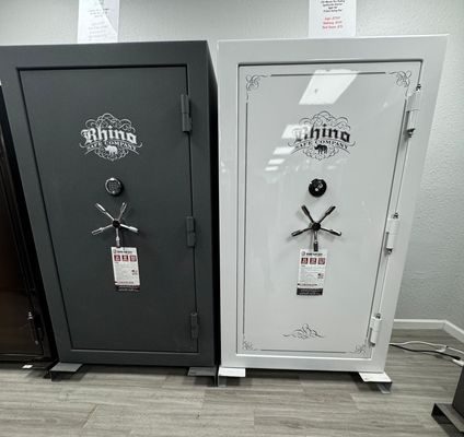 Two Rhino gun safes, dark gray and white, on display in a store.