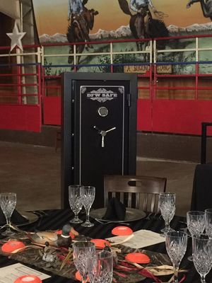Black safe at a formal dinner table with crystal glasses and a western-themed backdrop.