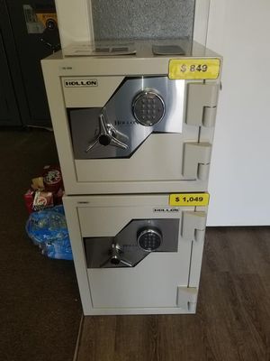 Two stacked beige Heller brand safes with digital and dial locks, priced $849 and $1,049 respectively.