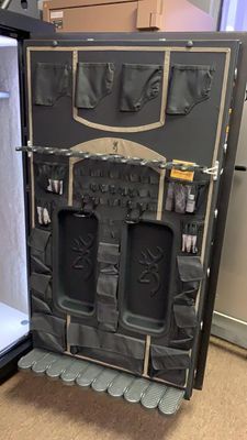 Inside of a black gun safe door with various storage compartments.