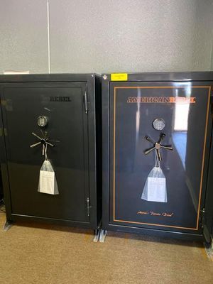Two black gun safes side-by-side. One reads 