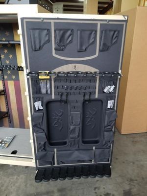 Interior of a gun safe door, with black storage pockets, pouches, and gun holders.