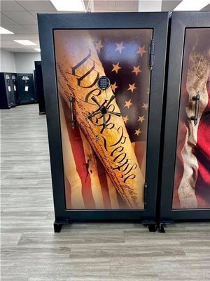 Black gun safe with Constitution and American flag design on a light gray floor.