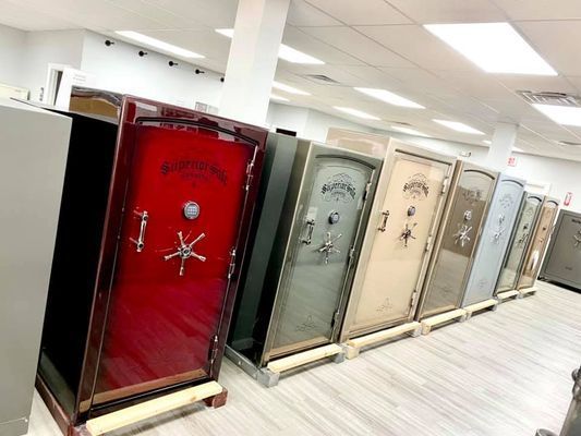 Row of large safes with different colors, in a showroom setting.