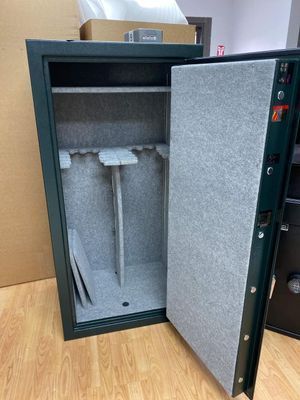 Open green gun safe with gray interior padding, holding gun racks. Door is open.