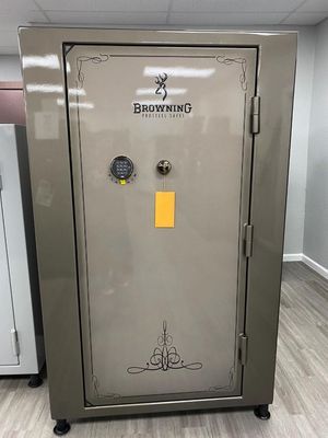 A large, tan Browning gun safe with a digital keypad and handle, indoors on a light wood floor.