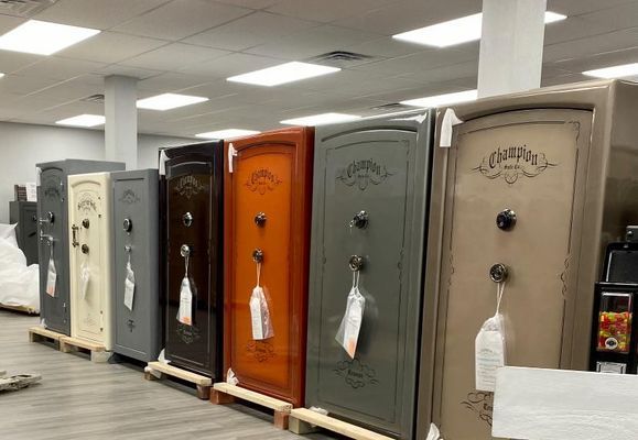 Row of colorful gun safes in a store; various colors, labels, and classic design.
