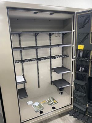Empty gun safe interior with adjustable shelves and door storage.