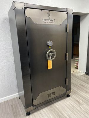 A dark gray Browning gun safe with a silver faceplate and electronic lock, in a room.