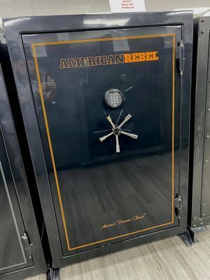 Black American Rebel safe with orange trim and combination lock.