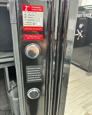 Close-up of a black Fort Knox safe door with buttons, labels, and fire protection details.