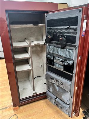 Open, empty red Fort Knox gun safe with door storage compartments.