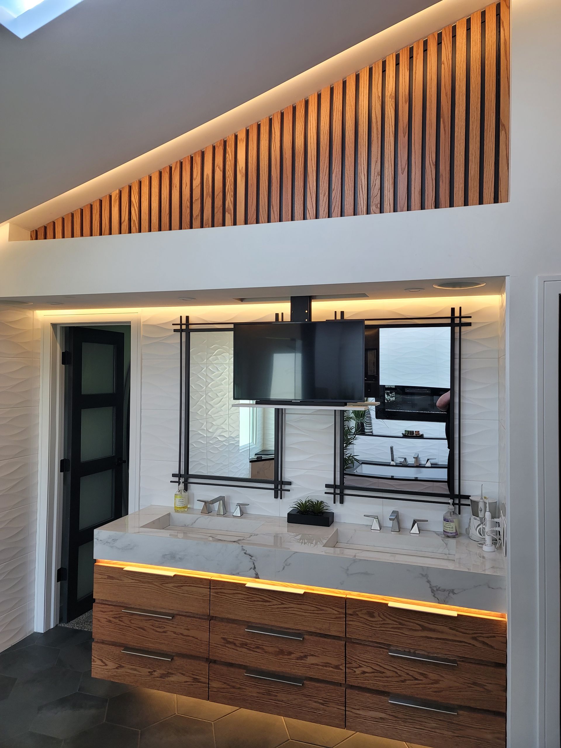 Modern kitchen with white counter, wood slatted accent wall, and warm under-cabinet lighting