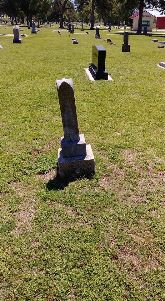 A cemetery with a lot of graves in the grass.