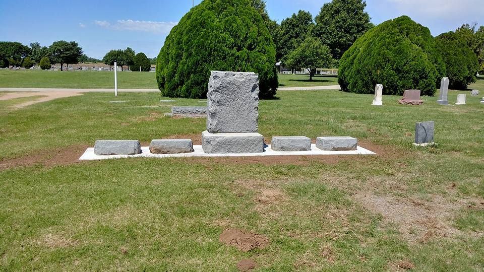 A grave in a cemetery with trees in the background