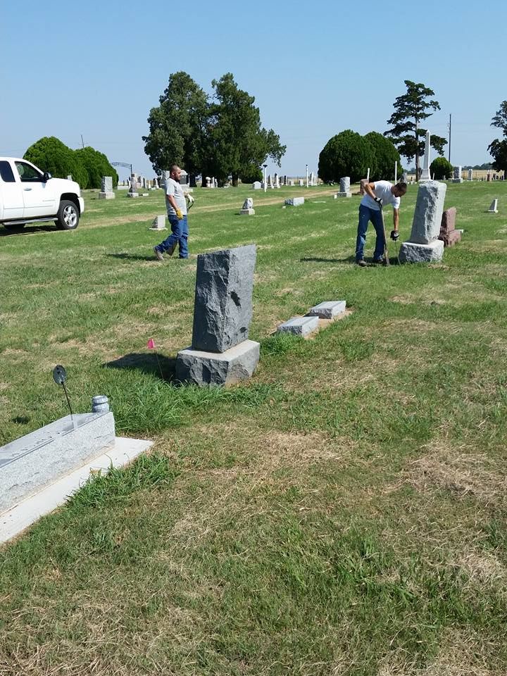 A cemetery with a white truck parked in the grass