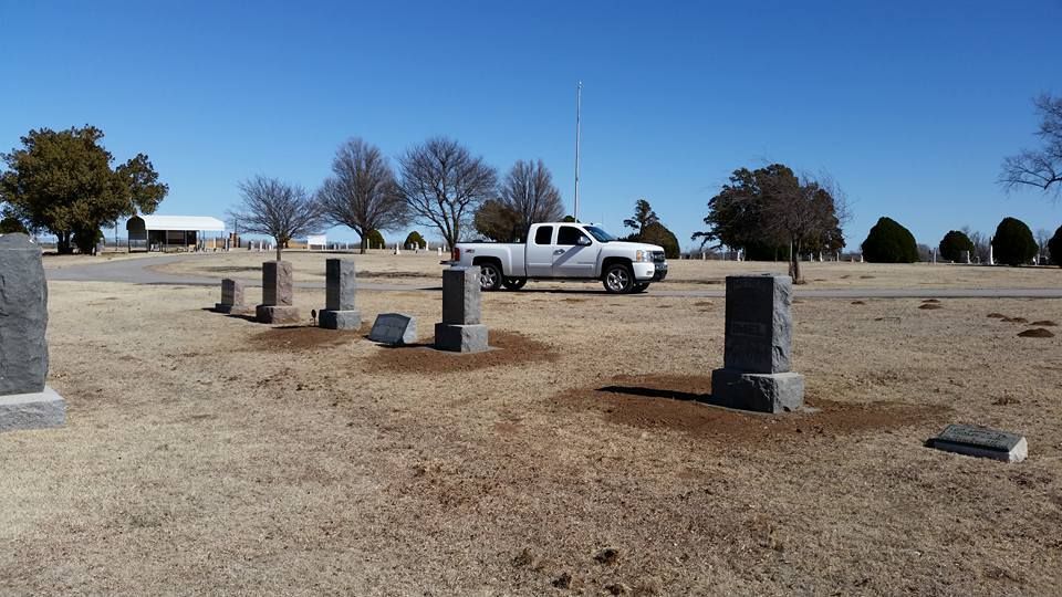 A white truck is parked in a cemetery