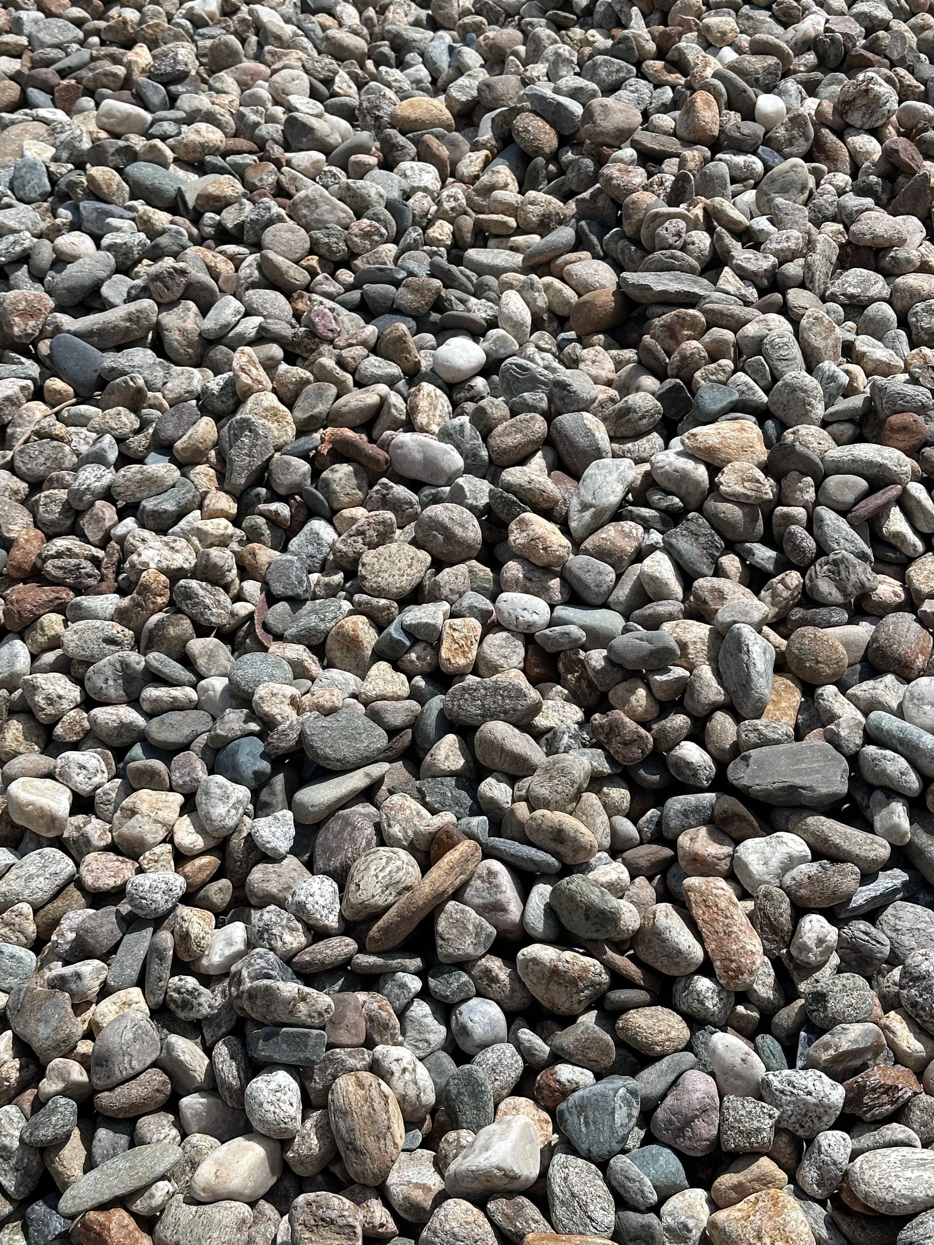 A large pile of gravel is sitting on the ground.