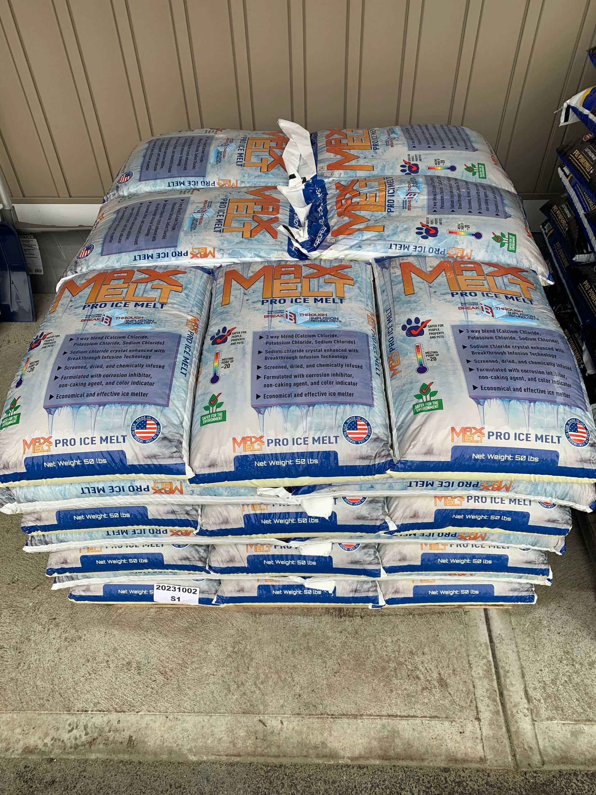 a stack of bags of snow is sitting on a sidewalk .