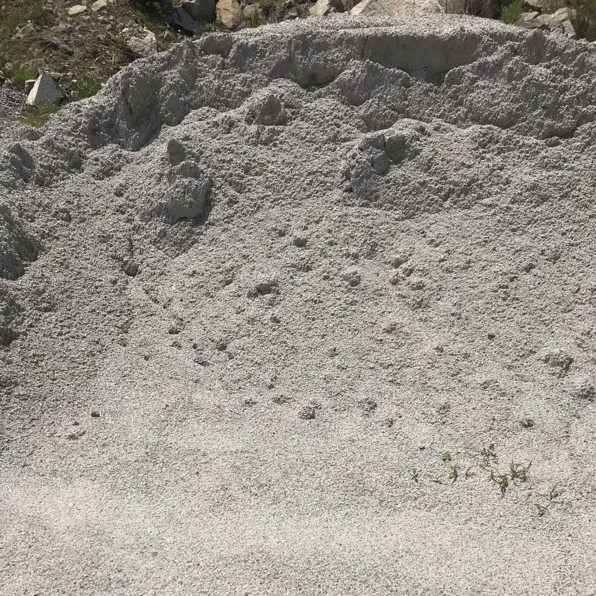 A pile of gravel is sitting on top of a dirt field.