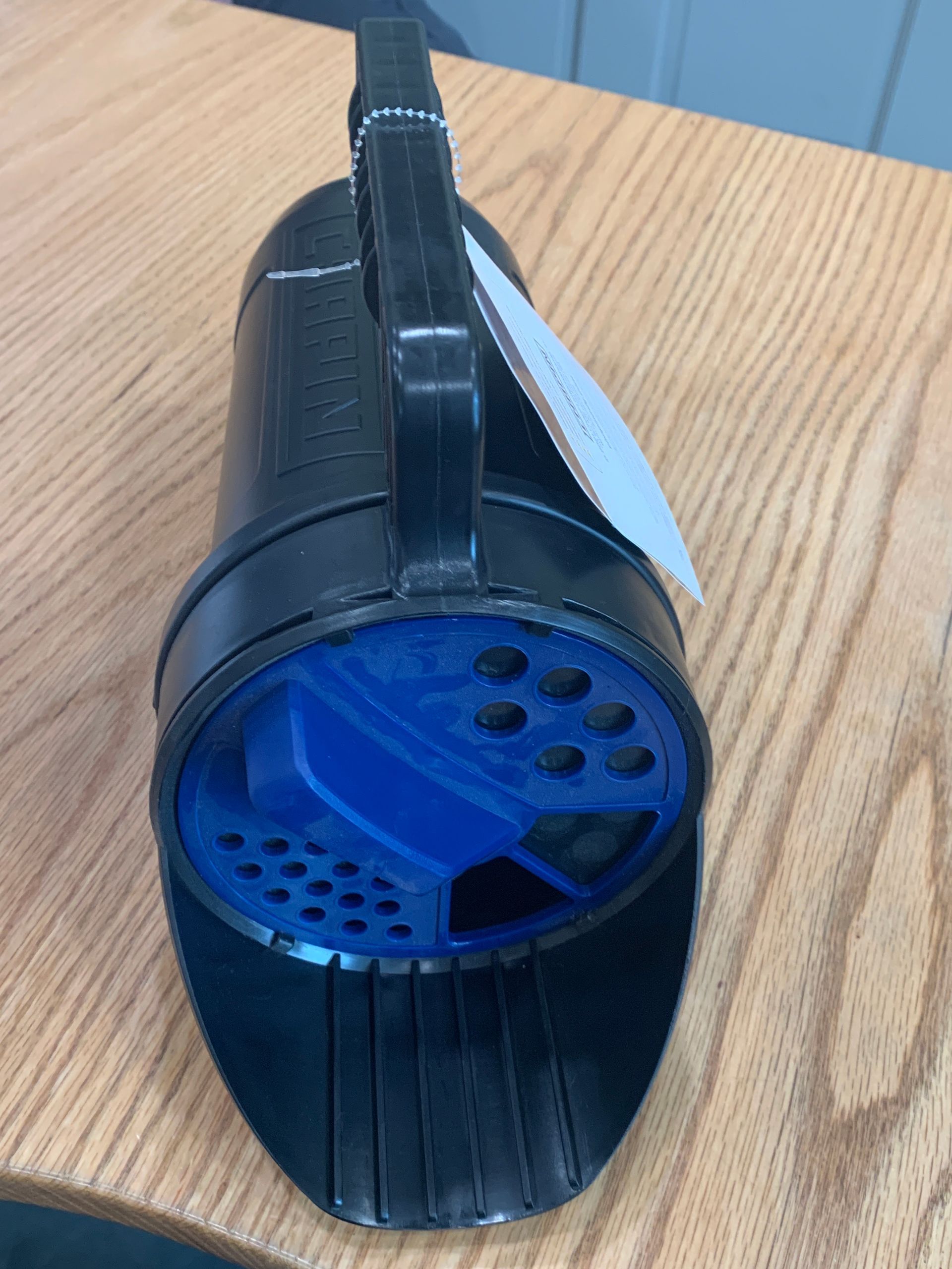 A black and blue object is sitting on a wooden table