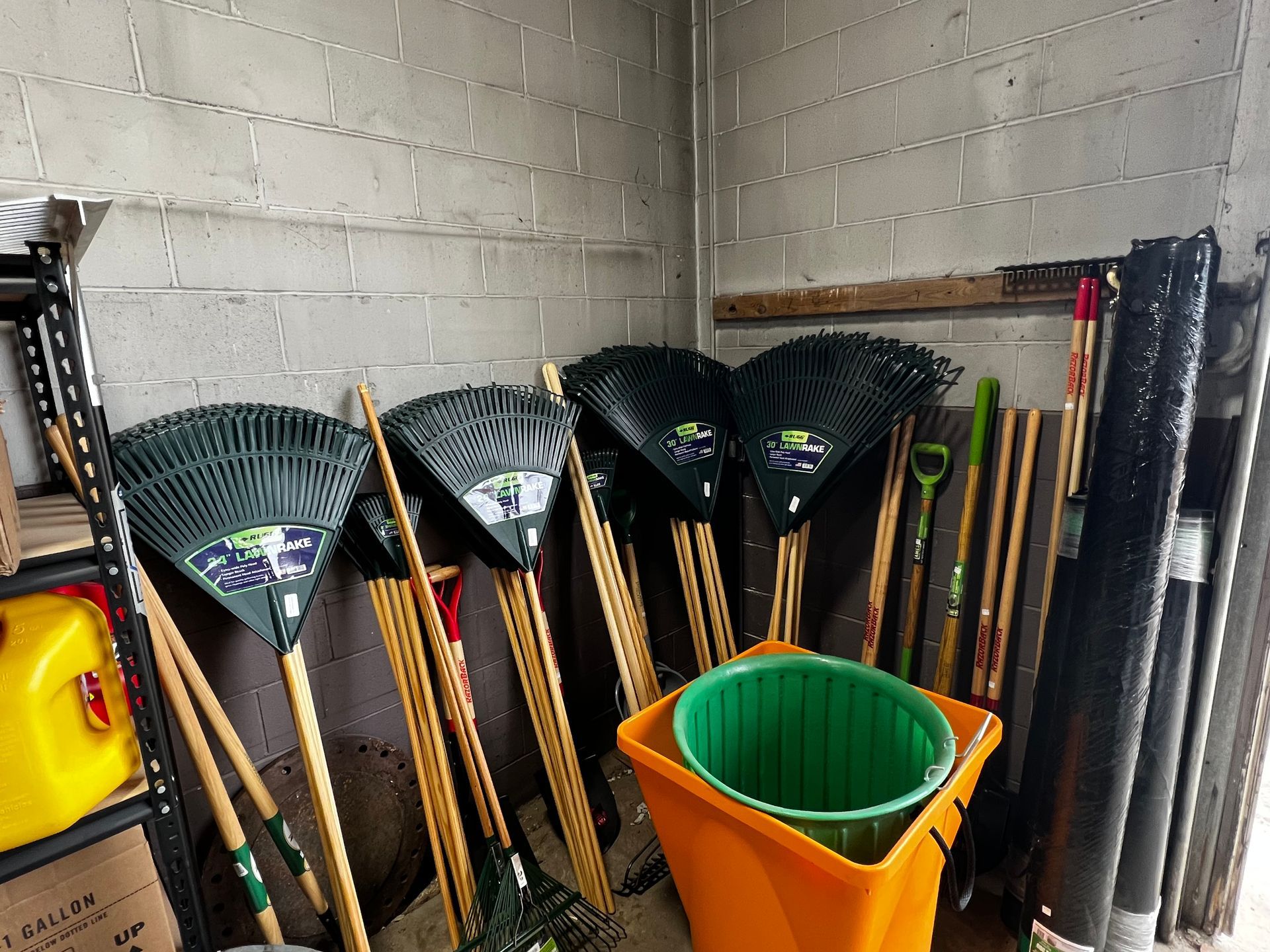 A bunch of gardening tools are lined up in a room