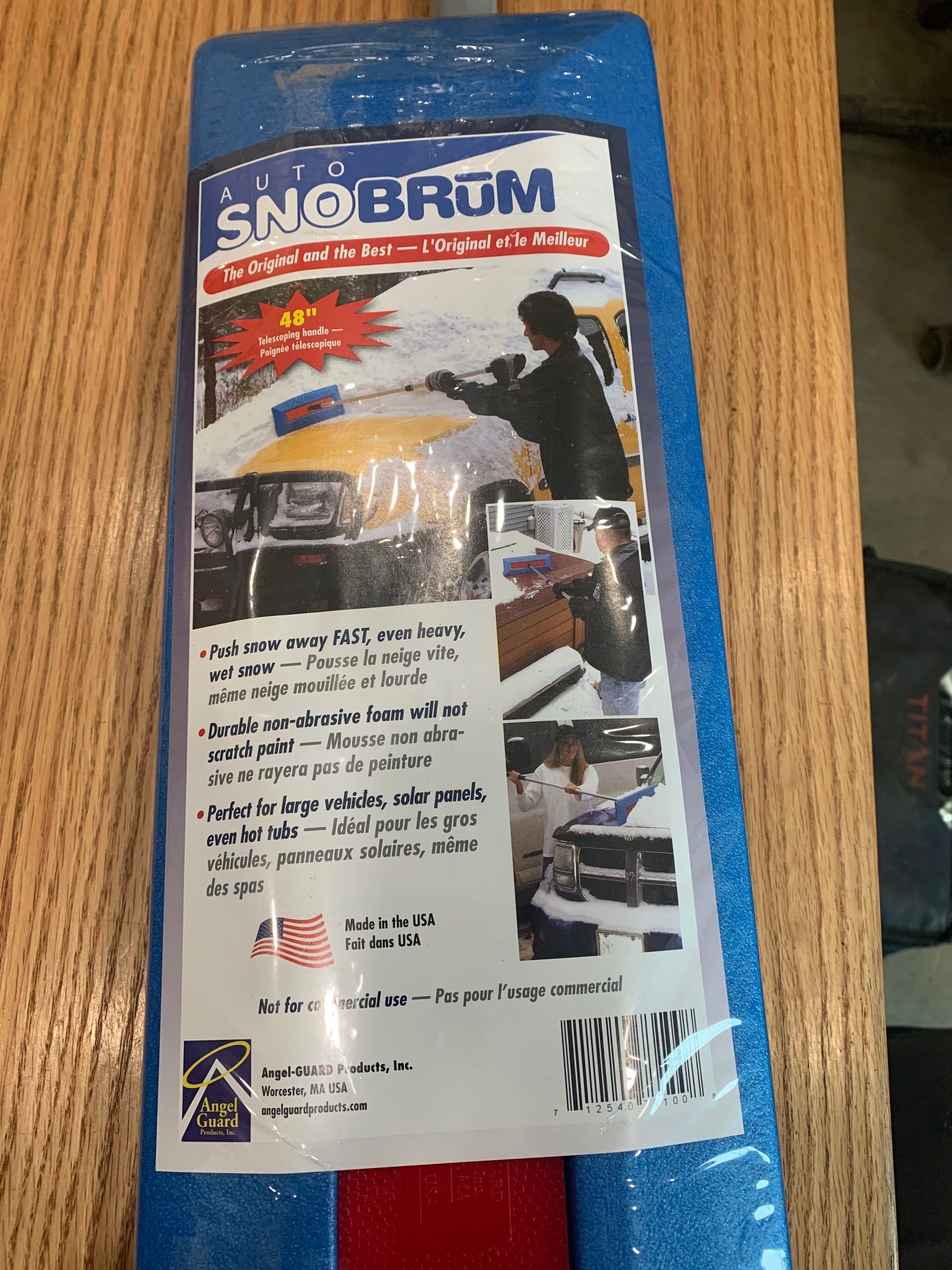 A snow broom is sitting on a wooden table