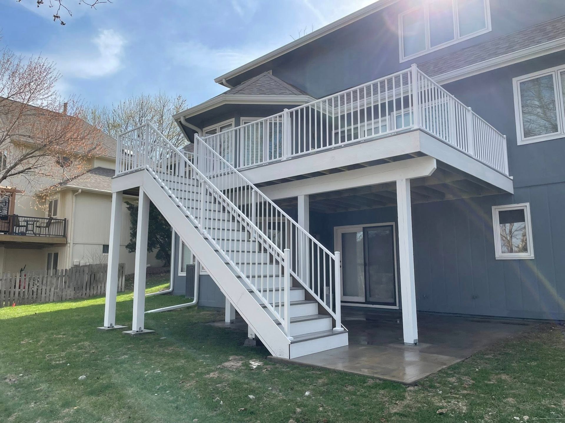 A blue house with a white deck and stairs