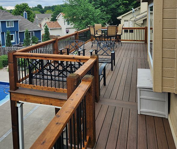 A large wooden deck with tables and chairs on it