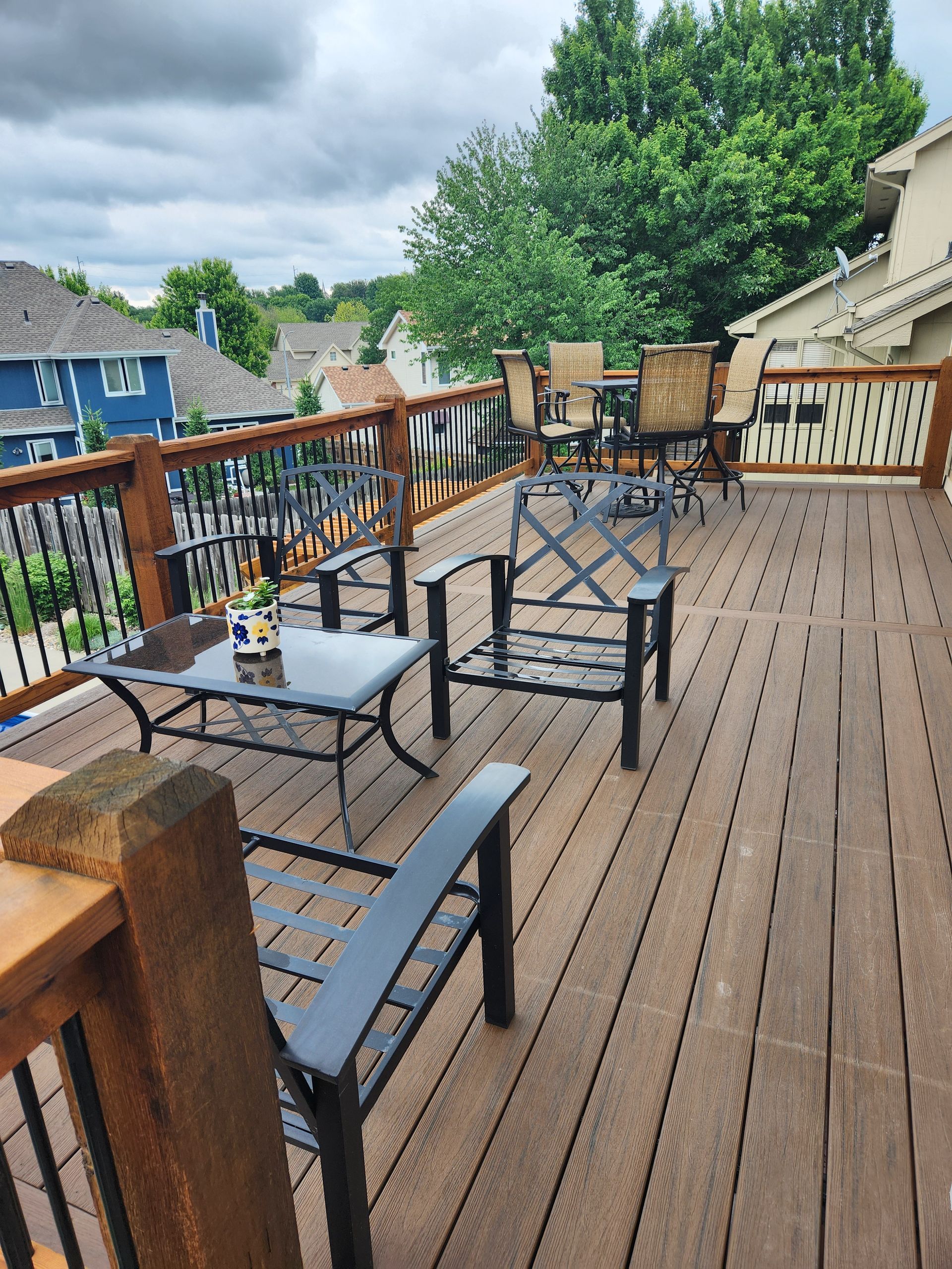 A wooden deck with chairs and tables on it