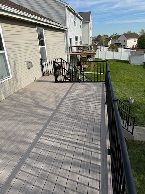 A deck with stairs leading up to it and a house in the background.