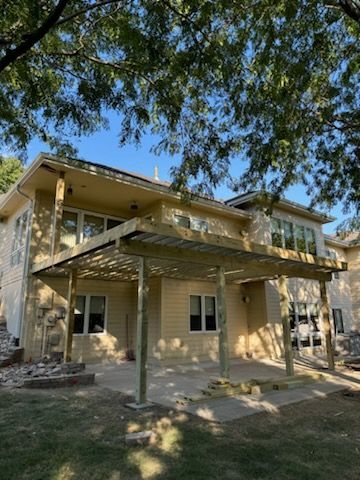 A large house with a pergola on the back of it.