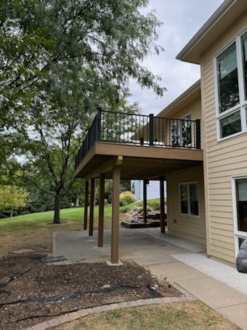 A large house with a large deck and a lot of windows.
