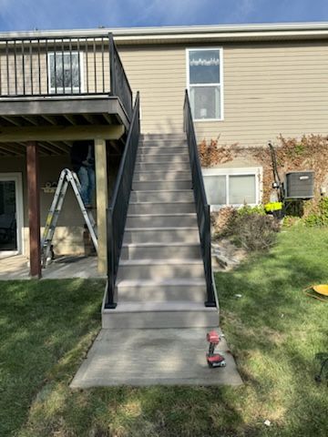 a set of stairs leading up to a deck in front of a house