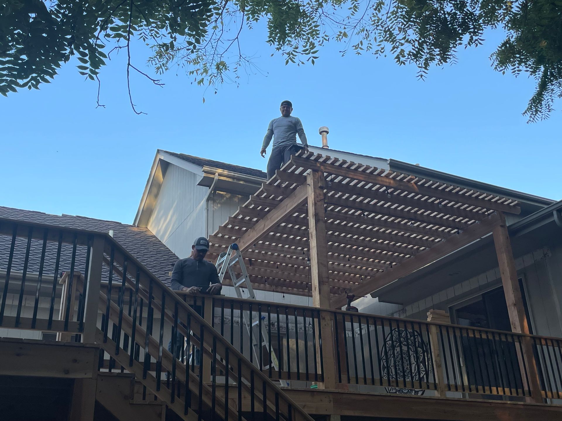 two men are standing on top of a wooden deck