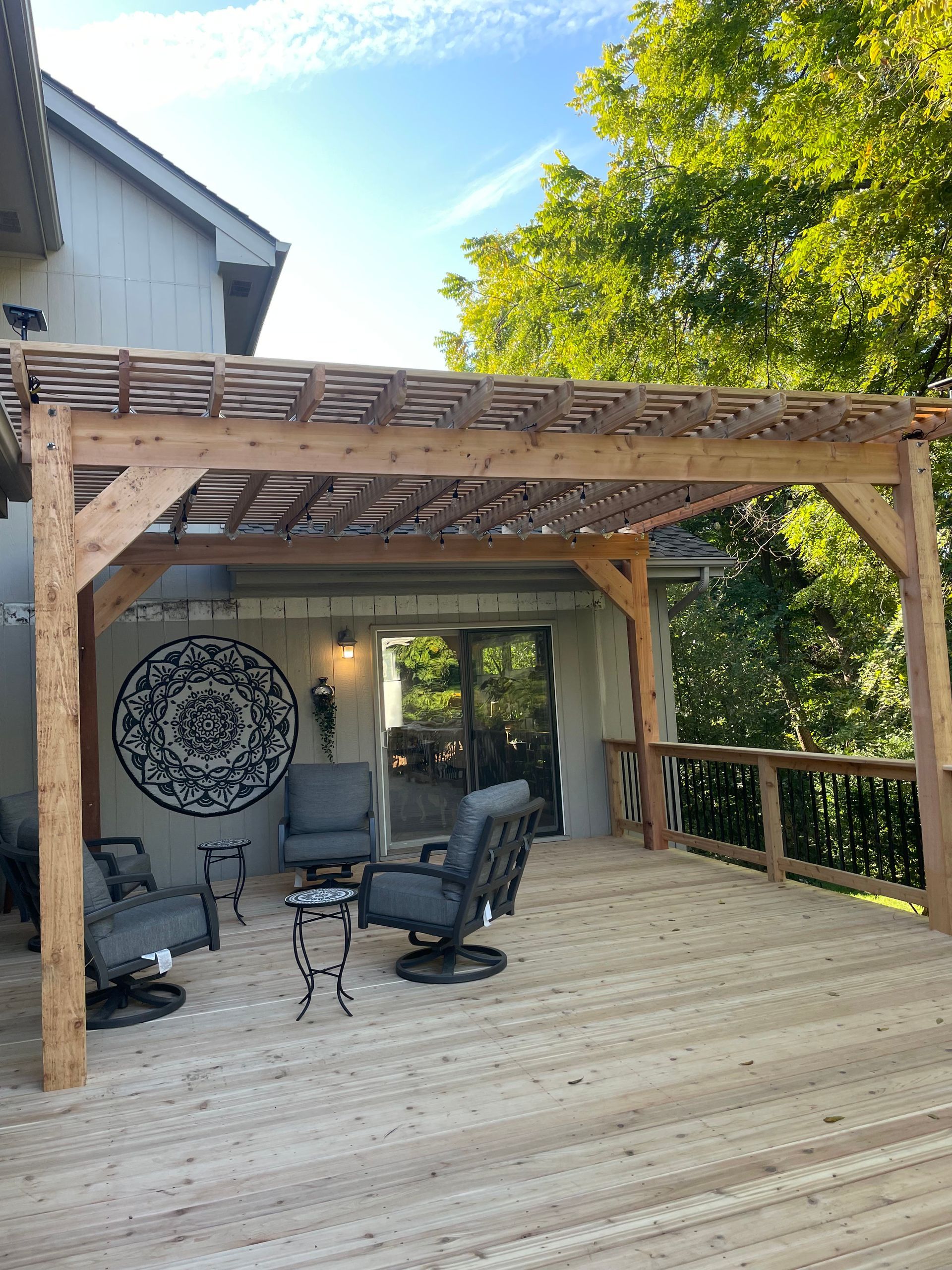 a wooden deck with a pergola and chairs on it